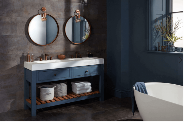 Phòng tắm hiện đại với bồn rửa kép, gương tròn, đèn treo tường và bồn tắm độc lập.